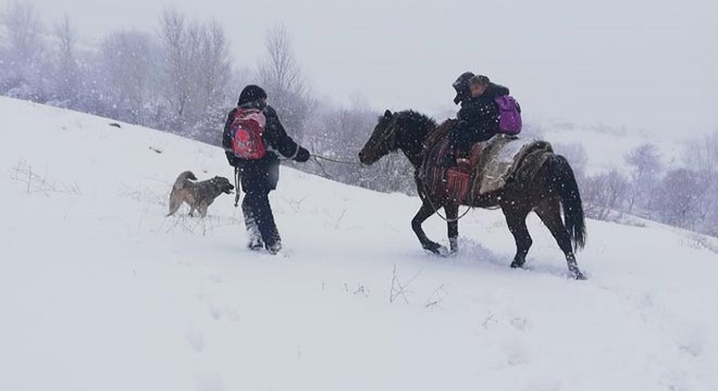Kar yolu kapatınca, çocukları at sırtında okula götürdü