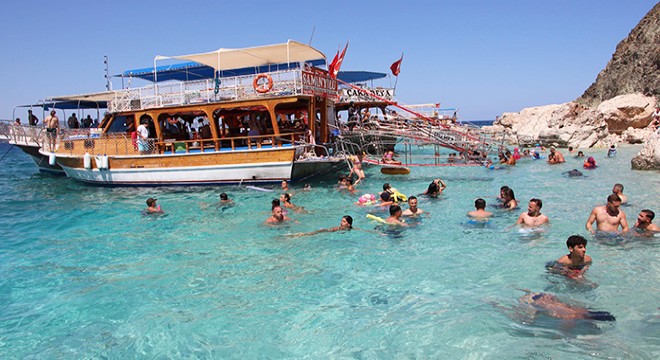 Tatilciler tekne turunda Antalya nın cennet koylarını görüp, serinliyor