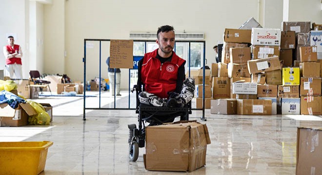 Tekerlekli sandalyesiyle depremzedelerin yardımına koşuyor