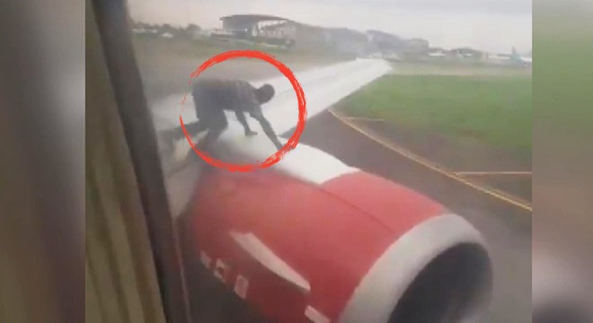 Uçağın kanadına tırmanan adam panik yarattı