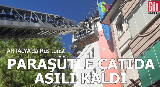 Antalya'da Rus turist, paraşütle çatıda asılı kaldı