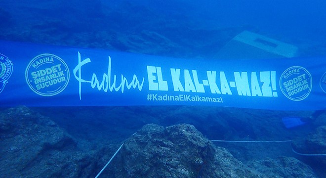 Deniz dibinde kadına şiddete karşı farkındalık için pankart