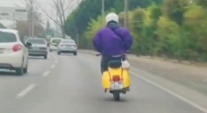 Elleri montunun cebinde olan motosiklet sürücüsü, kamerada