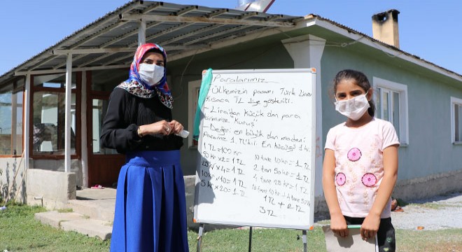 Gamze öğretmen, elinde tahtasıyla dolaşıp ders anlatıyor