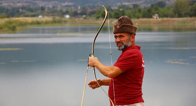 Geleneksel ok ve yay ile balık avlıyor