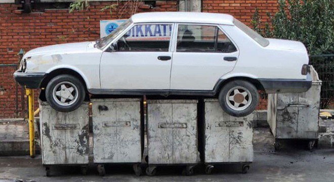 İş yerinin önünü kapatan otomobili çöpe attılar