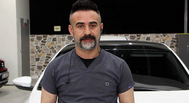 Kaporta ustası, araçları doktor kıyafeti giyerek tamir ediyor