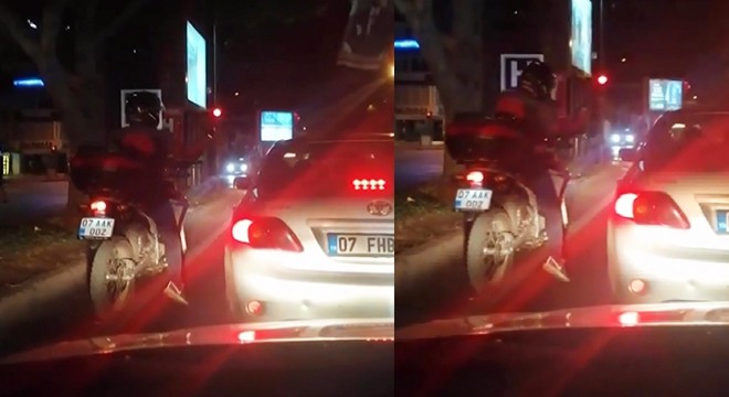 Kırmızı ışıkta beklerken, motosikletinin üzerinde oynadı