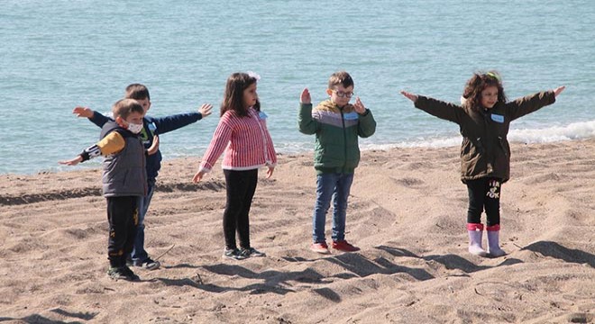 Minikler sahili temizleyip spor yaptı