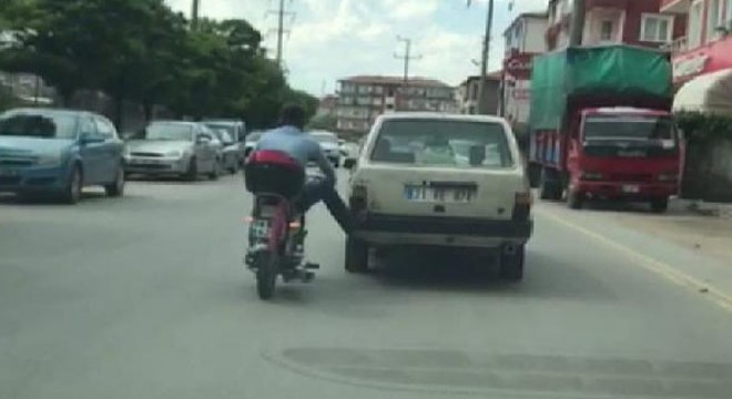 Motosikletiyle otomobilin arkasına takılarak istasyona gitti