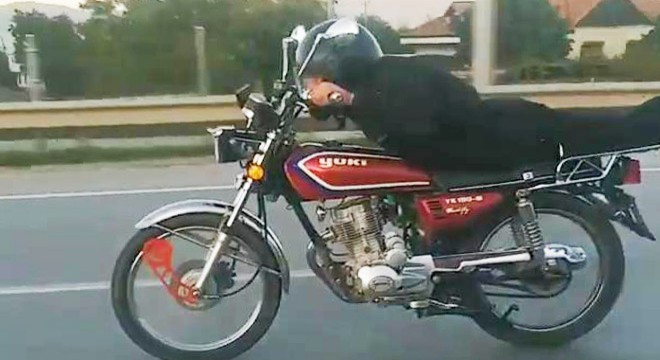 Plakasını söktüğü motosikleti yüzüstü yatarak kullandı