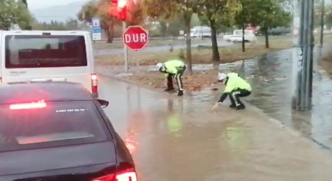 Polis memurları, tıkanan rögarı elleriyle açmaya çalıştı