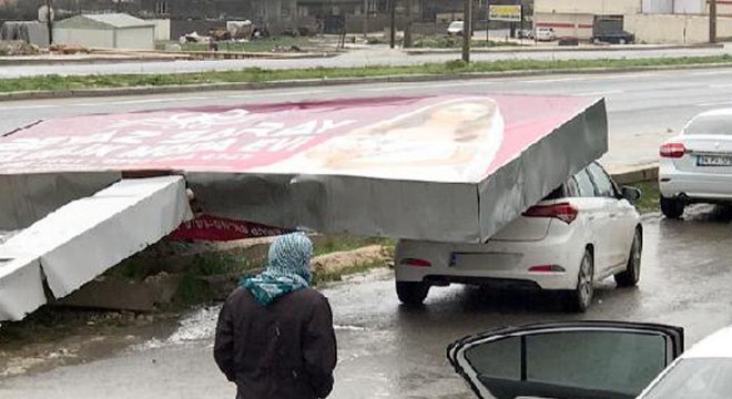 Reklam tabelası,  otomobilin üzerine devrildi