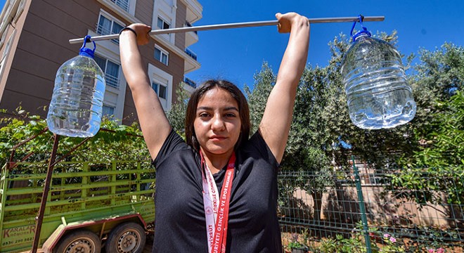 Şampiyon halterci, 5 litrelik su bidonlarıyla güç depoluyor