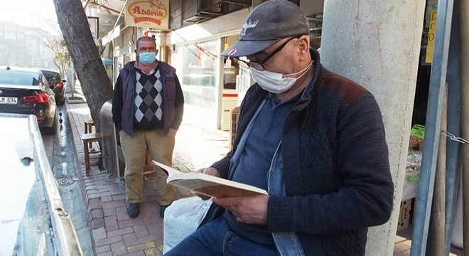 Seyyar tatlı arabasının başında elinden kitap düşürmüyor