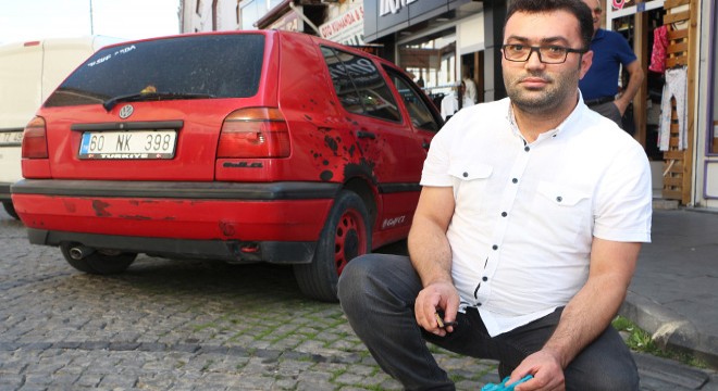 Sokaktaki sigara izmaritlerini makasla topluyor