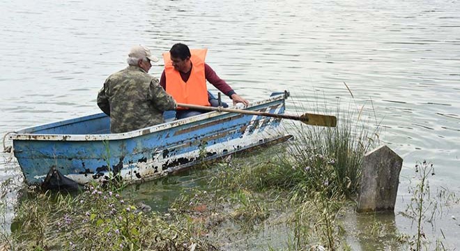 Su altında kalan mezarlığa sandalla gidip, dua ediyorlar