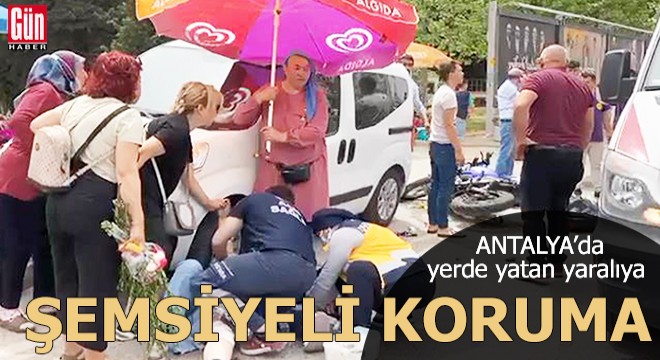 Yerde yatan yaralıya plaj şemsiyeli koruma